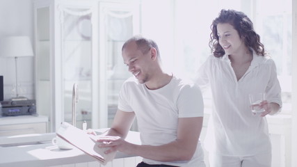 Young mixed race couple enjoying the early morning sunlight in their home