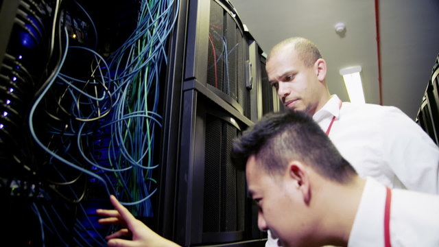 IT engineers in a data centre carry out a server rack inspection