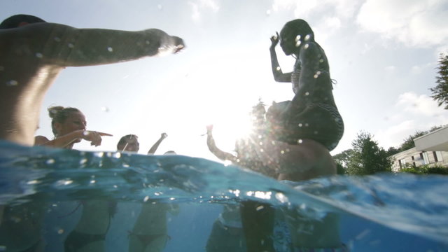 Happy Fun Loving Group Of Friends Playing In The Water At Summer Pool Party