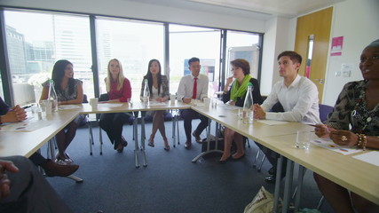 Mixed ethnicity business group in boardroom meeting or training seminar