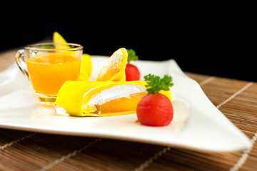 roll pancake mango with mango juice on black background
