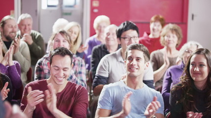 Mature male speaker addresses a public meeting - Powered by Adobe