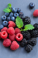 Assorted fresh berries on a black background, close-up