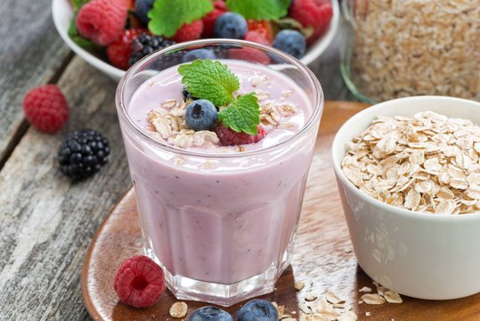 berry smoothie with oatmeal in a glass on wooden table, close-up