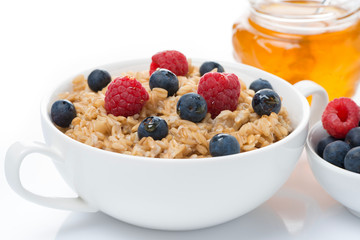 healthy breakfast - oat porridge with fresh berries and honey