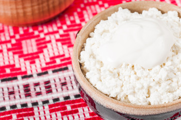 curd in brown bowl on the Ukrainian rushnyk
