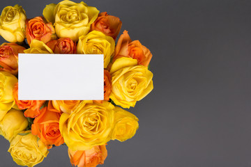 blank gift card and beautiful bouquet of orange and yellow roses