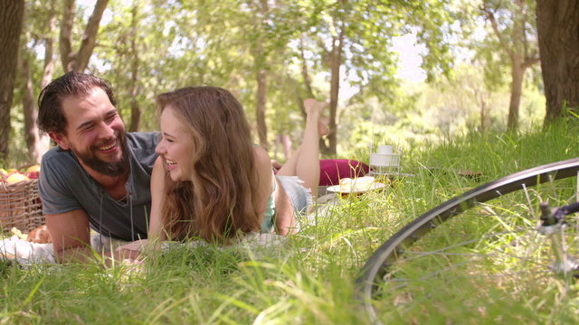 Happy couple having picnic with their bikes