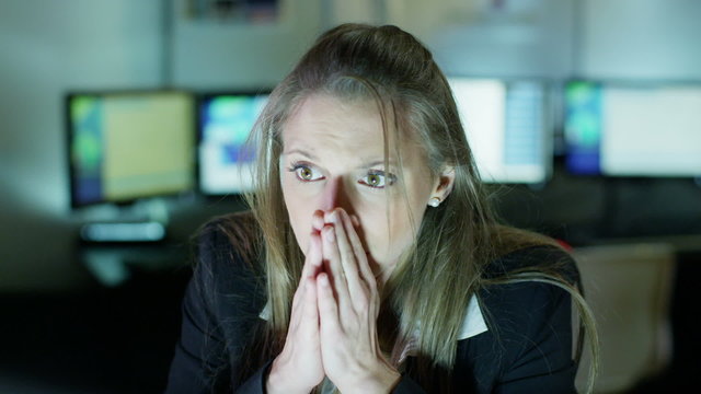 Businesswoman working late is upset by something she sees on her computer