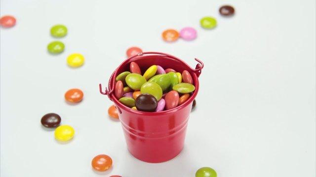 colorful chocolate candy falling into bucket