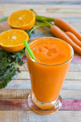 Orange-Karotten-Smoothie im Glas auf Holz