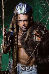 Werewolf with long nails and crooked teeth among the branches of