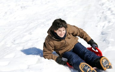Fototapeta na wymiar Guy plays with sledding on snow