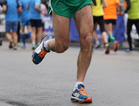 strong muscular legs of the athlete during the road race