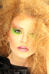 Extravagant woman with bright colored makeup and curly hairstyle