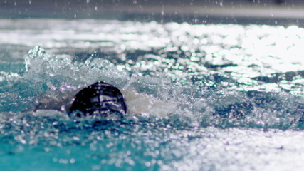 Powerful female swimmer in training doing the butterfly stroke 