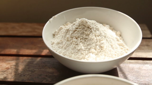 closeup transfer from wheat to rye flour on wooden table