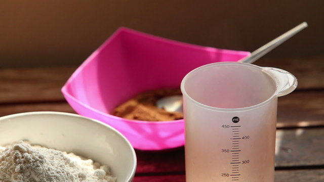 steam evaporates out of measuring cup standing on wooden table