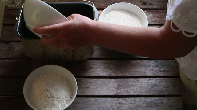 caucasian woman pours malt into container for bread baking