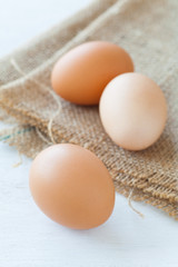 Healthy food brown chicken egg on brown fabric background