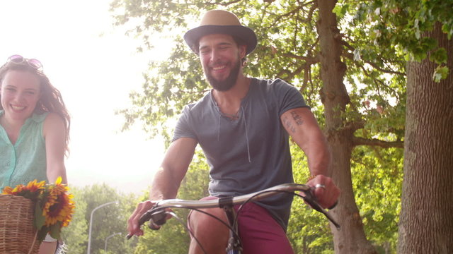 Young couple cycling happily together in Slow Motion