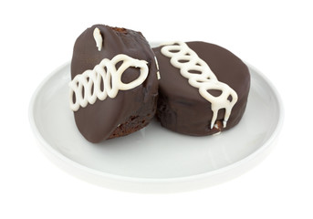 Two chocolate iced cakes on a small plate