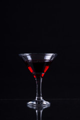 Red wine in a glass of martini on a black background