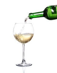 White wine pouring from the bottle intro the glass