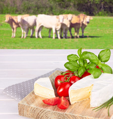 cow cheese, cherry tomato, and basil on a wooden background