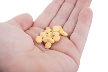 Hand holding yellow pills