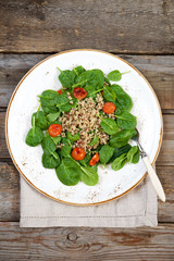 Fresh spinach salad with quinoa and roasted tomatoes