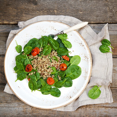 Fresh spinach salad with quinoa and roasted tomatoes