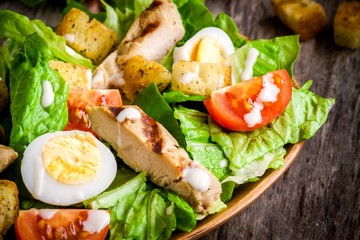 Caesar salad with eggs, cherry tomatoes and grilled chicken
