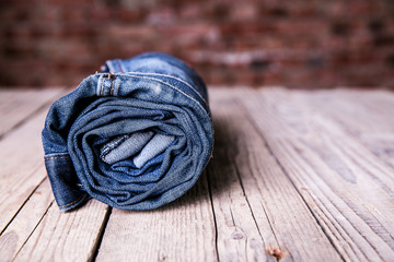 Clothing. twisted jeans on a wooden background