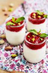 Homemade yogurt with raspberry and pistachio in glass jars