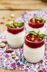 Homemade yogurt with raspberry and pistachio in glass jars