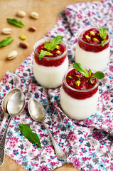 Homemade yogurt with raspberry and pistachio in glass jars