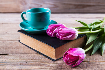 Cup of coffee on book with flowers.