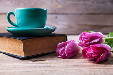 Fototapeta na wymiar Cup of coffee on book with flowers.