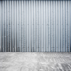 Garage interior with ridged metal wall and concrete floor