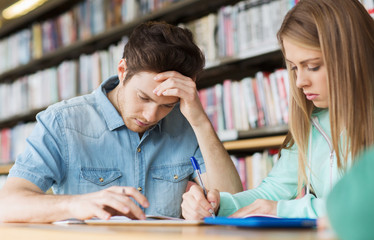 students writing to notebooks in library