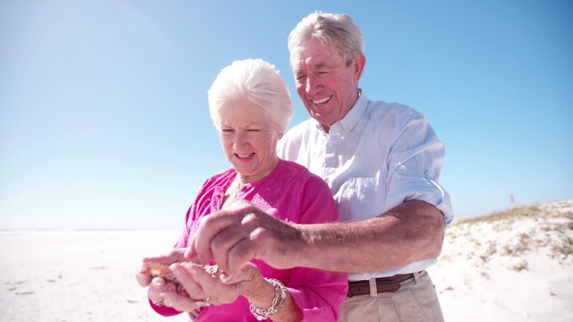 Elderly couple with collection of shells from the beach