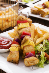 Grilled chicken skewers with pineapple, peppers and onions serve