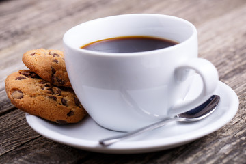 Cup of coffee with cookies on a table.