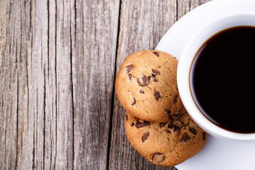 Cup of coffee with cookies on a table.