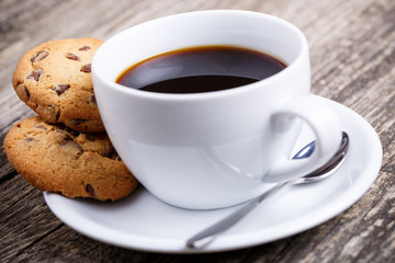Cup of coffee with cookies on a table.