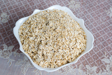 Dry oatmeal in a plate on  table