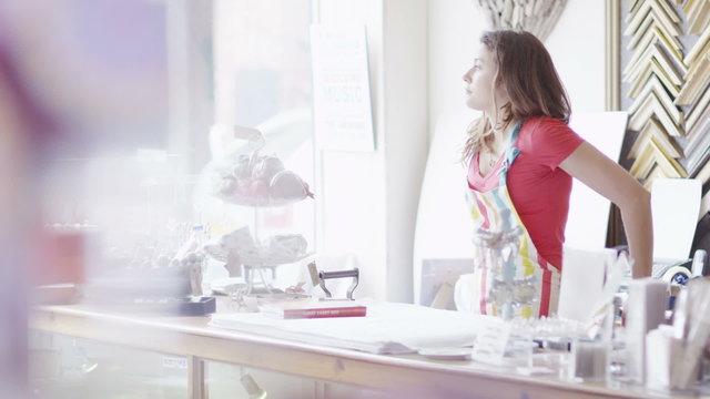 Bored Female Shopkeeper With No Customers