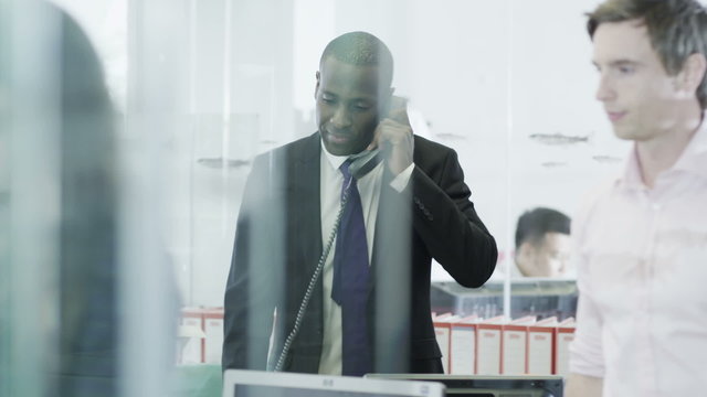 Confident and mature businessman on the phone in a modern office