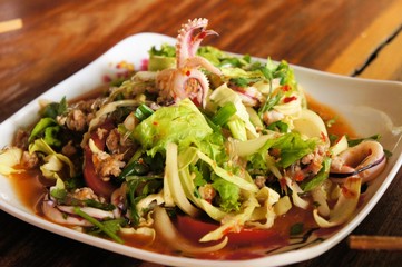 Thai seafood salad with squid over green leaf